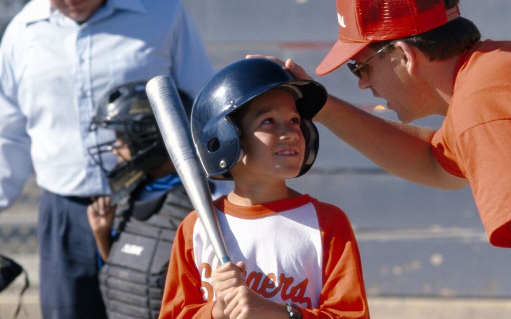 baseball coach speaking with kid